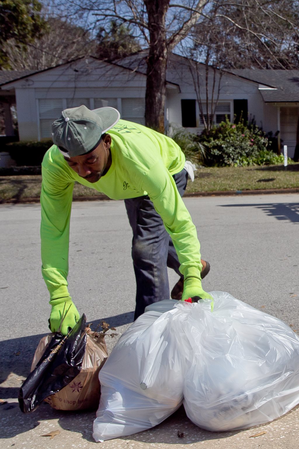 sanitation worker picks up bagged yard waste