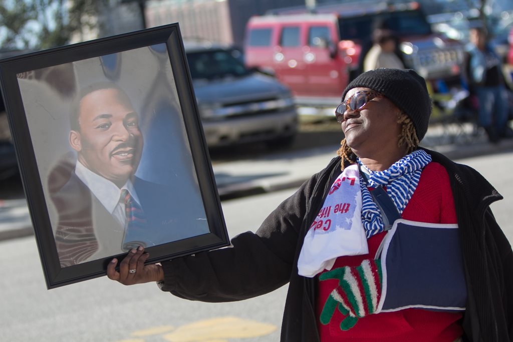 Woman holding a portrait of Dr. martin Luther King Jr. during the annual Martin Luther King Jr. Day Parade in downtown Jacksonville