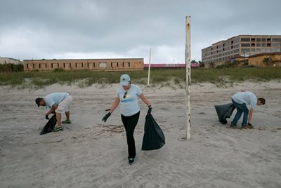 volunteers picking up trash on beach