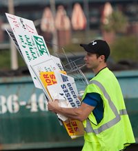 A City employee disposing of illegal snipe signs at a Tire & Sign Buyback event
