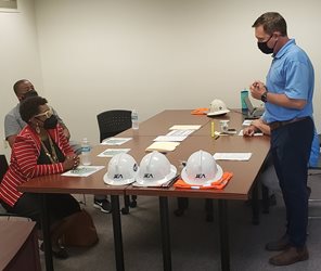 Photo of JEA employee Greg Corcoran explaining the septic tank phase out project and safety procedures to Council Member Pittman and City of Jacksonville Information Systems Administrator Eric Grantham prior to the site walk through.