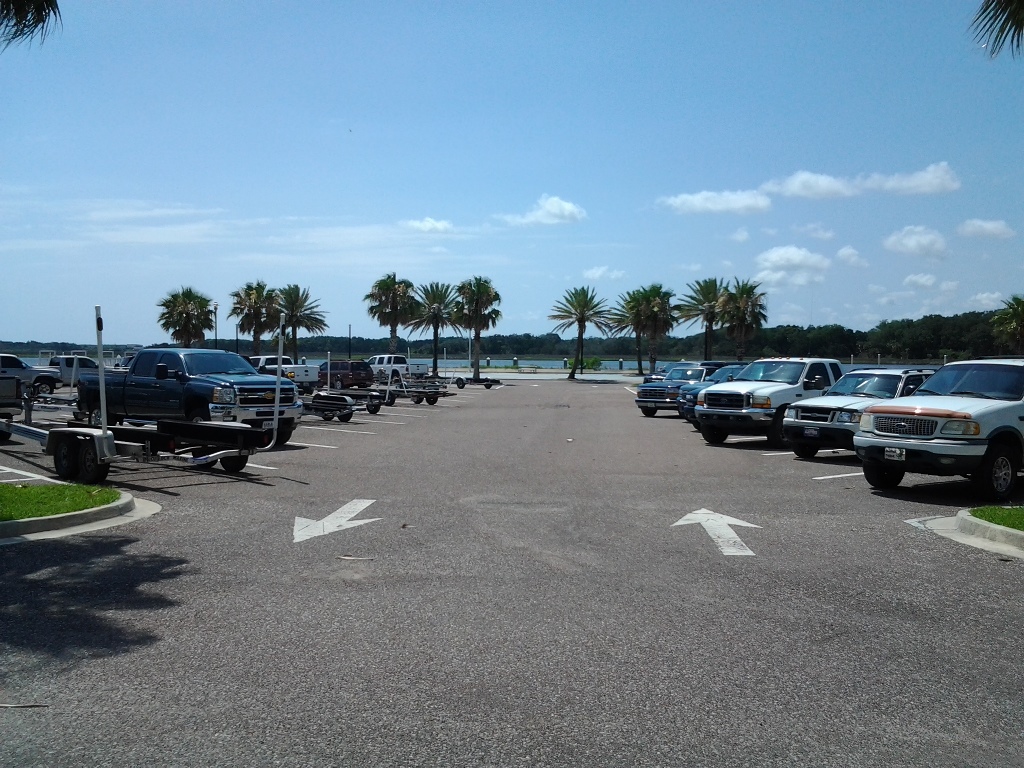 parking lot at boat ramp with trucks parked on both sides with boat trailers