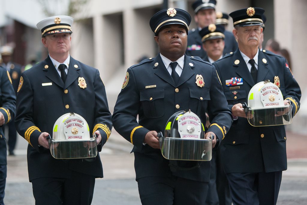 Firefighters holding the helmets representing their fallen brethren.