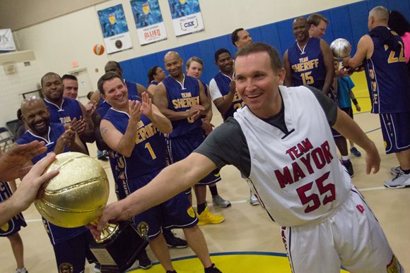 Mayor Lenny Curry holding the golden trophy for winning the 2016 Ballin' 4 PAL Charity Basketball Game against Sheriff Mike Williams