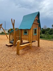 tree house like play structure with mulch underneath
