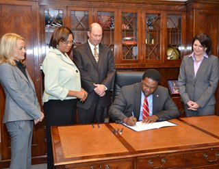 Mayor Brown signing the new bill into law