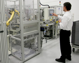A Saft employee oversees the robotic operation.