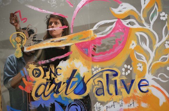 Nicole Holderbaum, artist and former SPARK grant recipient, creates a mural for the Arts Alive! project