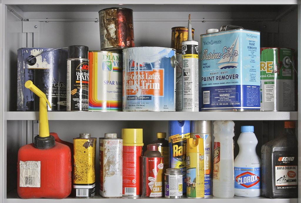 shelf filled with HHW products including paint cans and motor oil