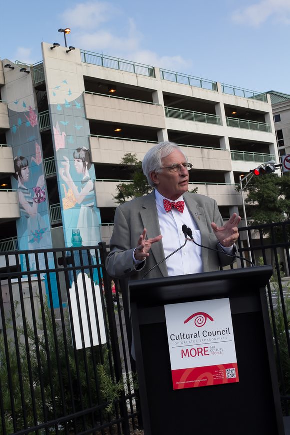 August 7, 2013 photo of Council President Bill Gulliford addressing the audience at the dedication ceremony for the new murals on the Yates Building parking garage.