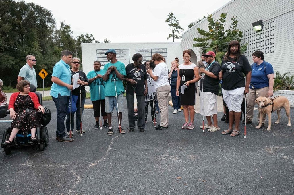 Blind person gather in the parking lot for a White Cane Safety Day walk