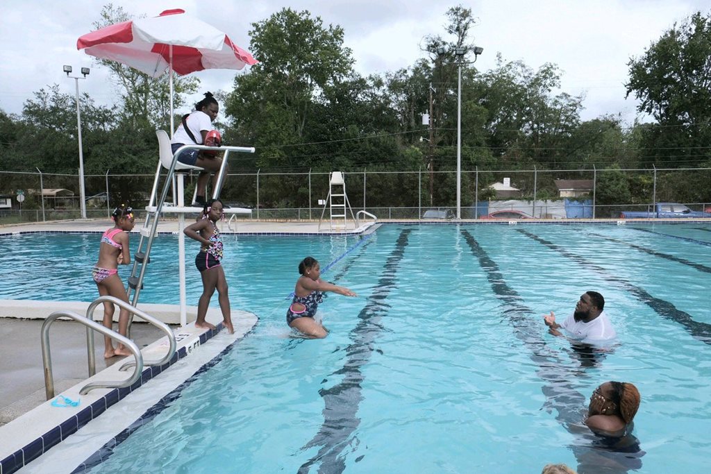 Children and adult swimming in pool