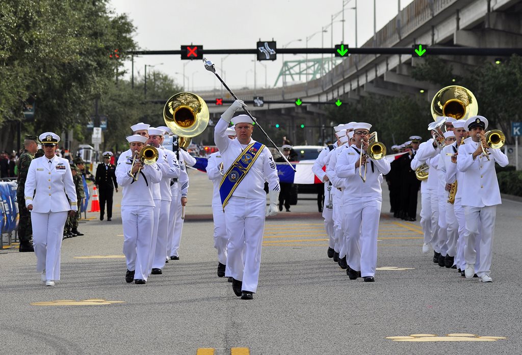 Navy band walking in parade and playing instruments