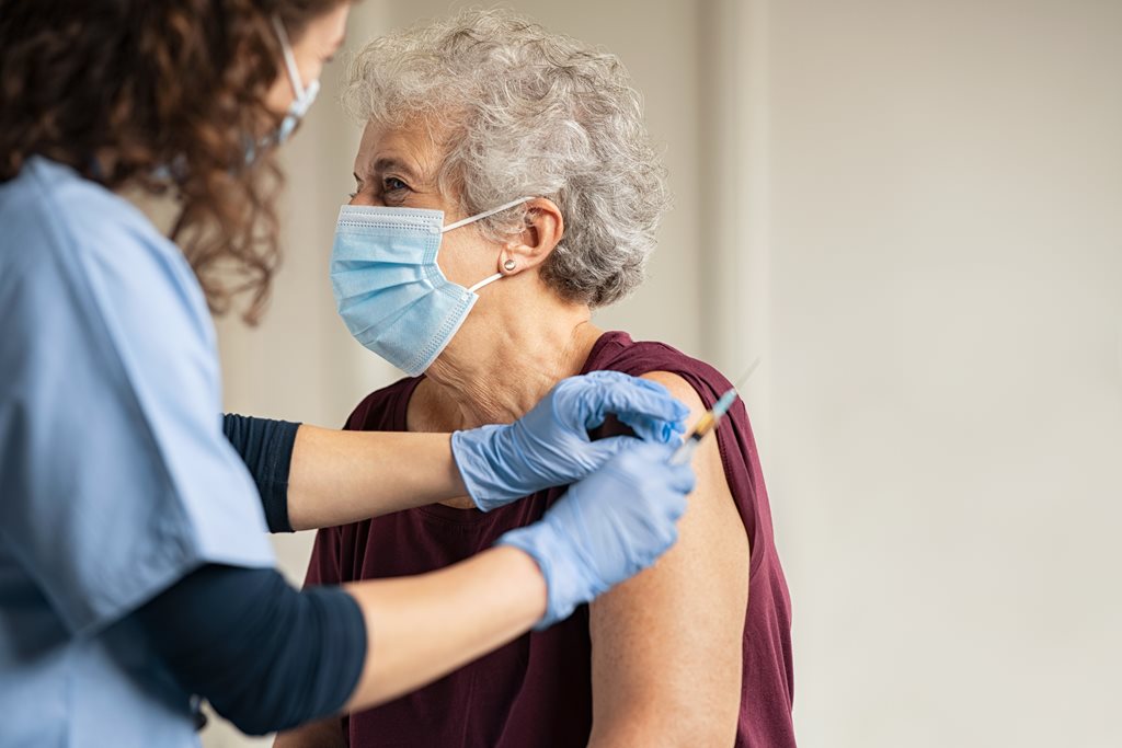 elderly woman receiving vaccine shot
