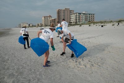 volunteers picking up trash on the beach