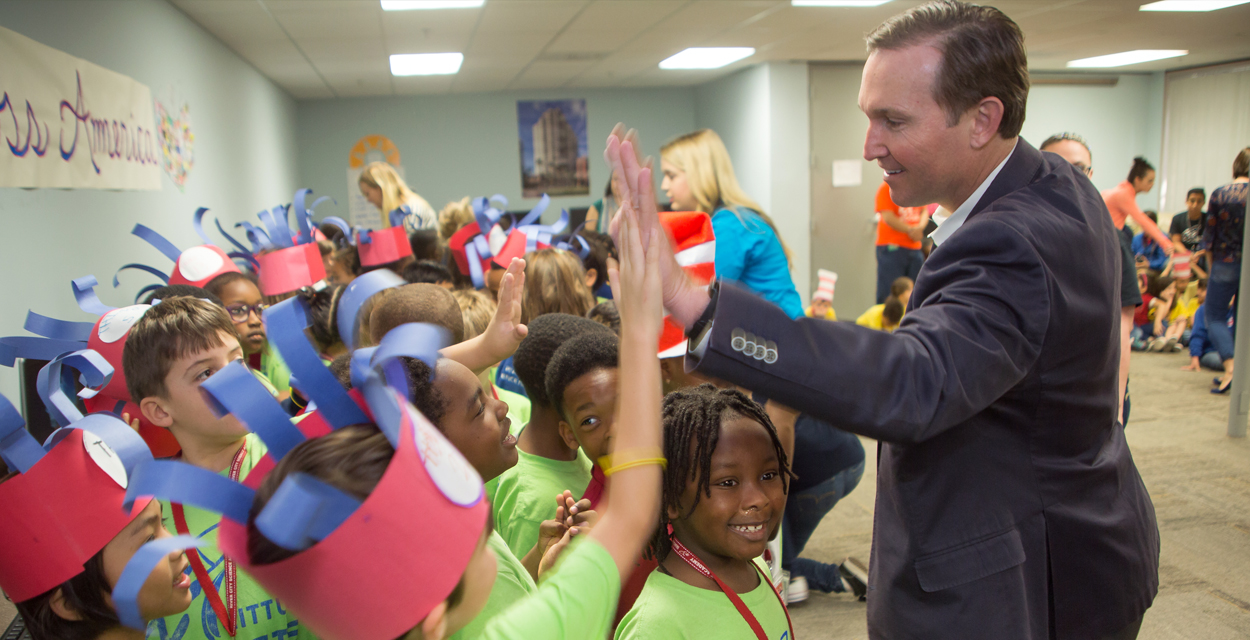 Mayor Curry high-fiving students on Read Across America Day 2018 at River City Science Academy's Innovation campus.