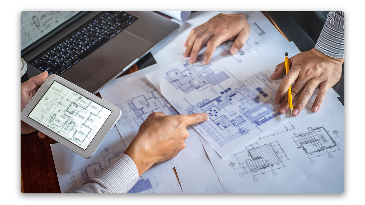 Two people working on blueprints