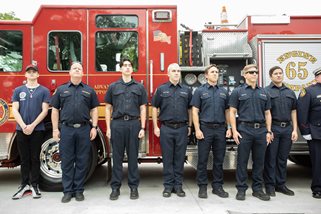 Firefighters standing in front of firetruck