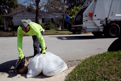 City employees collecting garbage from a residence