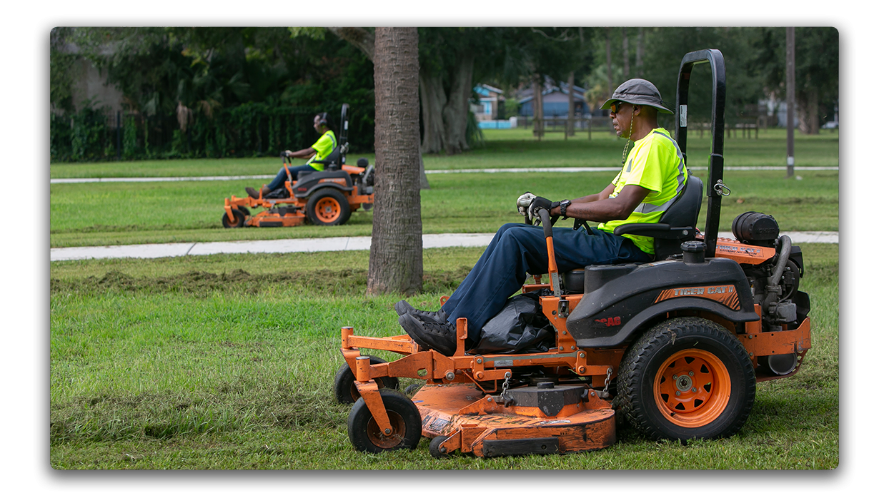 Public Works employees mowing grass