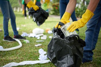 people wearing yellow gloves picking up trash