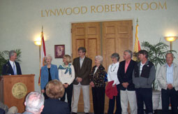 Photo of the Roberts Family standing in front of the doors to the newly dedicated Lynwood Roberts Room in City Hall.