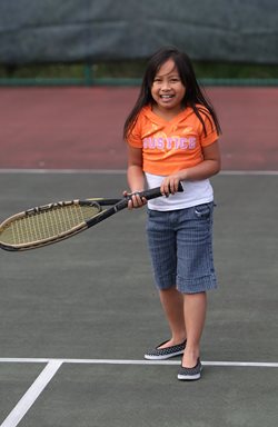 small girl playing tennis