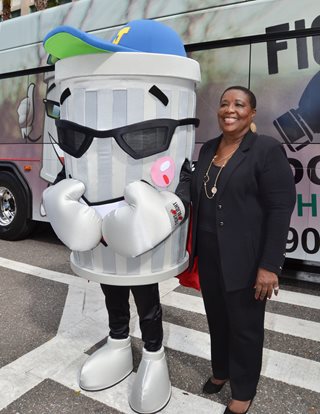 Photo of Council Member Denise Lee with the Fight the Blight Mascot.
