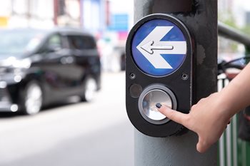woman pressing button for crosswalk signal