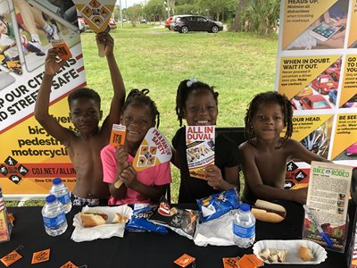 four young smiling children at the all in duval booth