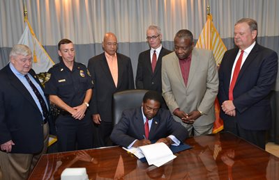 Mayor Brown signing the agreement with the Police and Fire Pension Fund Board of Trustees and Executive Director John Keane